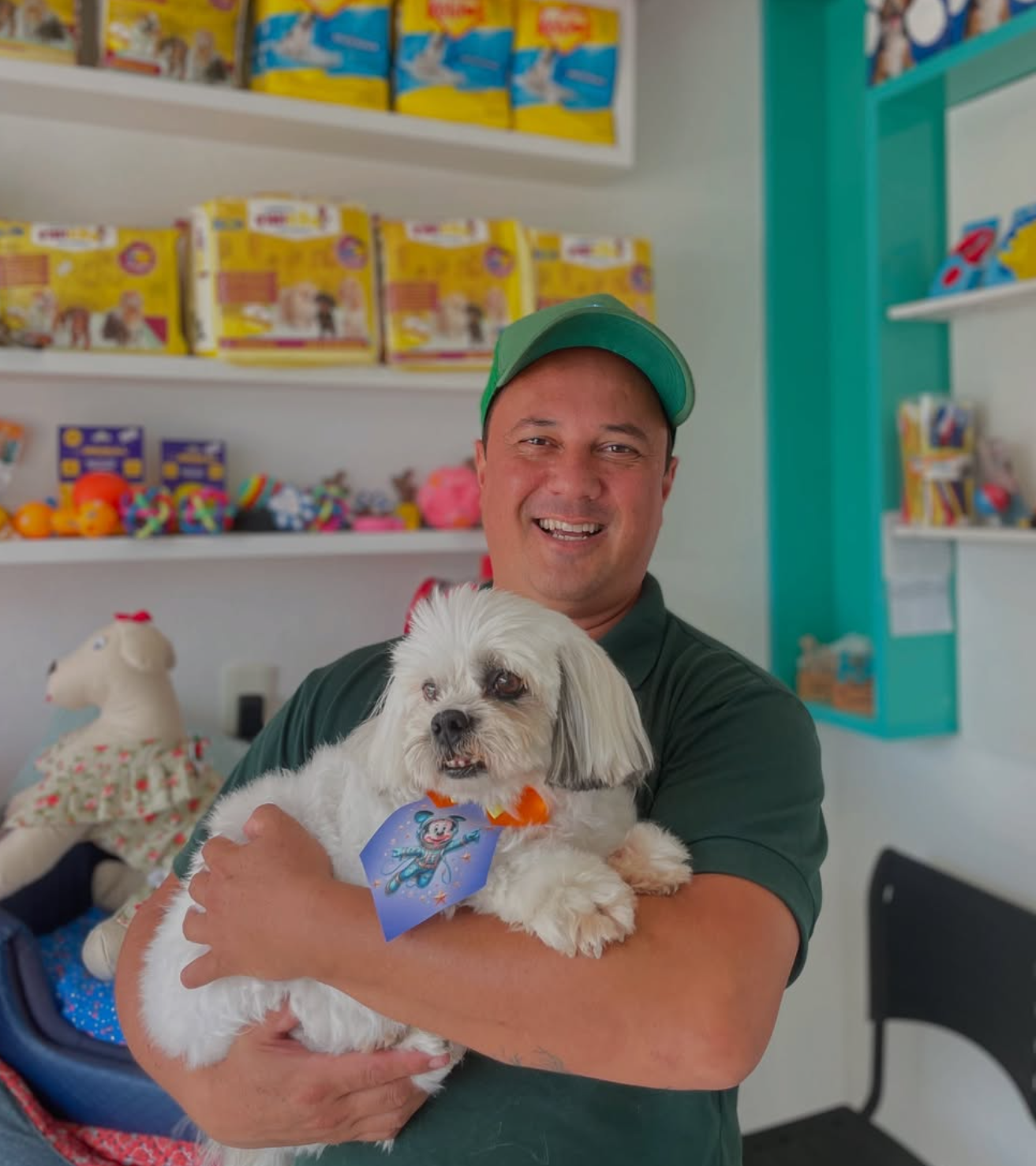 Profissional do Pet Mais+ segurando um cachorro branco