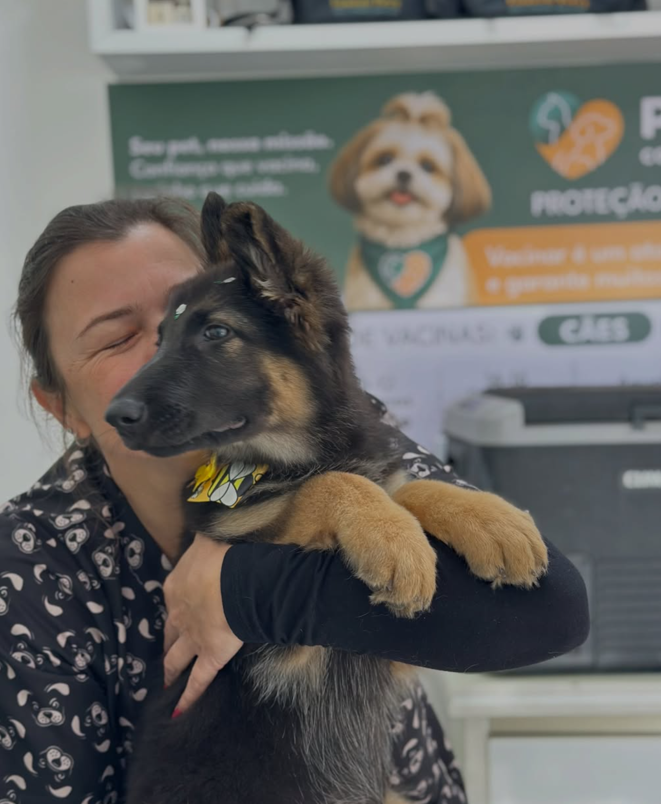 Profissional do Pet Mais+ abraçando um cachorro durante o atendimento